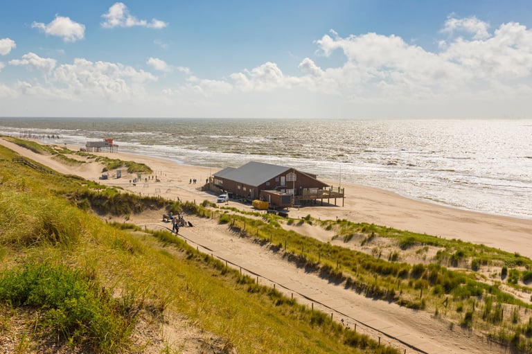 View from the dunes of Petten aan Zee, Noord-Holland province, The Netherlands, along the beach with beach bar and rescue station